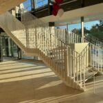 Foyer-Treppe mit Zwischenpodest und beidseitigem Geländer, weiß lackiert von Stahlbau Nägele.