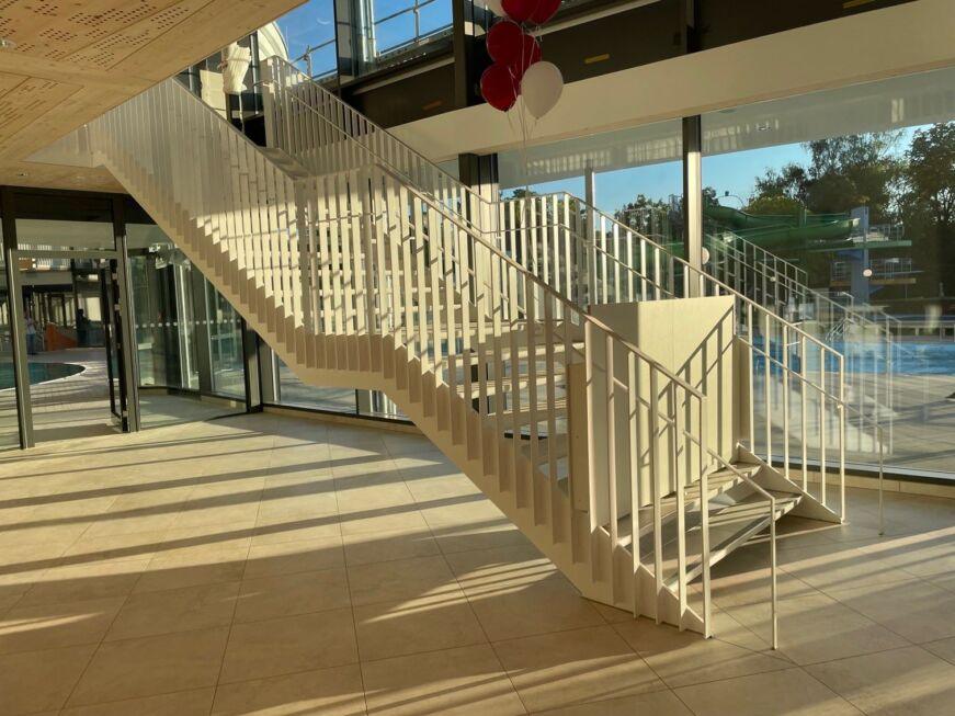 Foyer-Treppe mit Zwischenpodest und beidseitigem Geländer, weiß lackiert von Stahlbau Nägele.