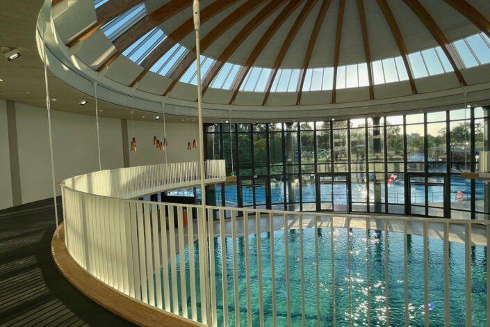 Innenansicht des Wunnebads in Winnenden, mit weißem Geländer und Holzhandlauf von Stahlbau Nägele.