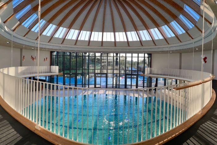 Innenansicht des Wunnebads in Winnenden, mit weißem Geländer und Holzhandlauf von Stahlbau Nägele.